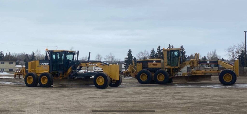 Two graders lined up in yard